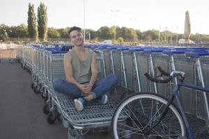 jovem, homem anda com bicicleta fixa, meio urbano, foto de hipster com bicicleta nas cores azuis