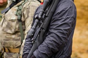 treinamento masculino com espingarda de ação de bomba ao ar livre em campo. foto