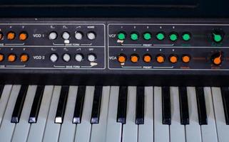sintetizador antigo com interruptores coloridos em fundo azul foto