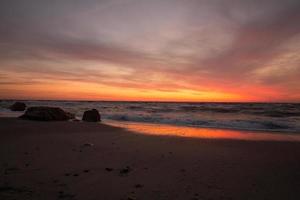 bela paisagem do mar na hora do nascer do sol, céu colorido rosa e laranja e tempestade no mar. foto