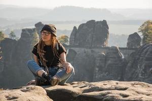 mulher jovem com carrinho de mochila no antigo castelo alemão no parque nacional da suíça saxônica foto