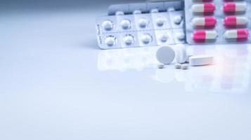 comprimidos brancos comprimidos em cápsulas branco-rosa borradas e comprimidos redondos em blister. produtos de farmácia. indústria farmacêutica. saúde e medicina. mercado farmacêutico no novo normal