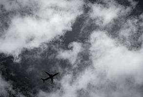 avião voando no céu escuro e nuvens brancas. companhia aérea comercial com conceito de destinos de sonho. conceito de crise de negócios de aviação. voo de férias de viagem falhou. transporte aéreo. viagem triste. foto