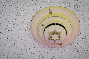 detector de fumaça velho e sujo com teias de aranha na parede do teto. sistema de alarme de incêndio em casa não funciona. equipamento de emergência no apartamento precisa de serviço de limpeza e manutenção. sensor de monóxido de carbono. foto