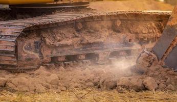 retroescavadeira trabalhando cavando o solo no canteiro de obras. dentes de balde de terra de escavação de retroescavadeira. escavadeira de esteiras cavando no solo. máquina de escavação. máquina de terraplenagem. veículo de escavação. almofada de trilha. foto