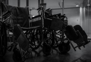 cadeira de rodas vazia no hospital à noite para pacientes de serviço e pessoas com deficiência. equipamento médico no hospital para assistência a idosos deficientes. cadeira com rodas para atendimento ao paciente em casa de repouso. foto