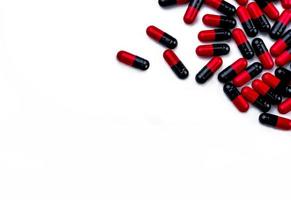 comprimidos de cápsula vermelho-preto isolados no fundo branco com espaço para texto. conceito farmacêutico. indústria farmacêutica. conceito de farmacologia e toxicologia. produto de farmácia. uso de drogas no hospital. foto