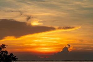 lindo céu por do sol sobre o mar tropical. céu dourado do sol. horizonte no mar. beleza na natureza. vista da praia tropical. vista panorâmica do céu pôr do sol. camada de nuvens vermelhas e laranja no céu. foto