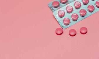 pílula de comprimidos rosa vista superior no fundo rosa. banner da web de cuidados de saúde. vitaminas e suplementos para mulheres. indústria farmacêutica. câncer de mama ou tópicos de saúde da mulher. conceito de dia mundial da saúde.