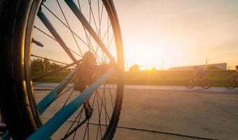 borrão foto esportes homem andar de bicicleta com movimento de velocidade na estrada à noite com céu pôr do sol. exercício ao ar livre de verão para uma vida saudável e feliz. ciclista andando de bicicleta de montanha na ciclovia. equipe.