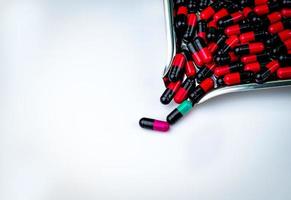 pílula cápsula preto-rosa, preto-verde e preto-azul e bandeja de drogas. resistência a antibióticos. pílulas cápsula antimicrobiana. fundo de farmácia. indústria farmacêutica. conceito de mutação genética.