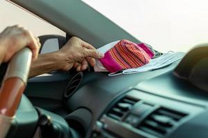 muitas máscaras faciais são colocadas no carro com as mãos. foto