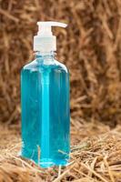 garrafa azul de gel com uma pilha de palha. foto