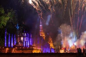 fogos de artifício coloridos com o antigo templo de sukhothai à noite. foto