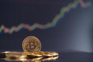 bitcoin golden coin group símbolo de moeda criptográfica e castiçal de gráfico de ações para cima tendência vitória estoque fundo desfocado no computador de negócios uso tecnologia criptomoedas blockchain close-up moeda. foto