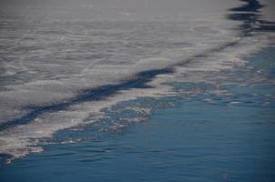 longa rachadura no gelo no lago foto