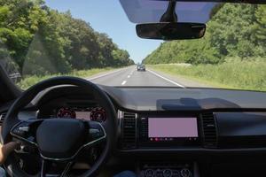 interior do carro na estrada. volante, painel e display de bordo foto