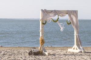 cenário de cerimônia de casamento de madeira na praia foto