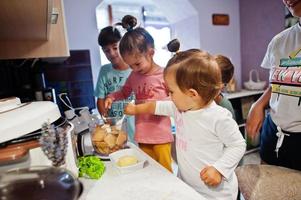mãe com filhos cozinhando na cozinha, momentos infantis felizes. foto