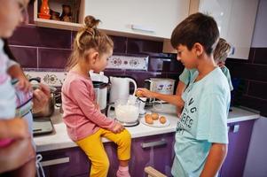 mãe com filhos cozinhando na cozinha, momentos infantis felizes. foto