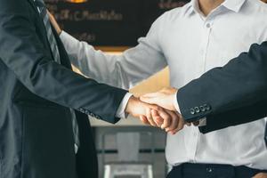 aperto de mão de empresário terminando uma reunião, juntar as mãos, apoiar juntos e unificar, conceitos de equipe de sucesso e felicidade foto