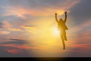 silhueta de homem de negócios celebração sucesso felicidade pôr do sol noite céu fundo foto