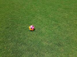 bola de futebol colorida na grama em um campo foto