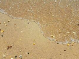 areia com ondas e pedras foto