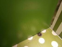 parede de box de banheiro verde sujo com dreno no chão foto