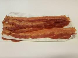 tiras de bacon e papel na superfície branca ou mesa foto