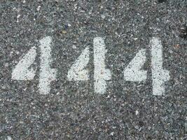 o número 444 pintado no asfalto preto foto