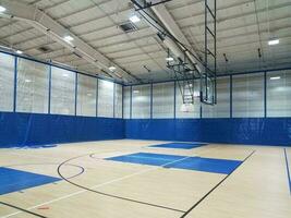 quadra de basquete com piso de madeira no ginásio foto