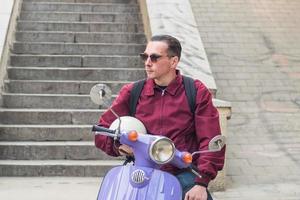 jovem homem elegante com scooter colorida foto