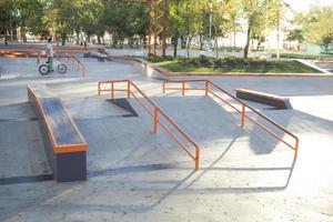 bmx rider treinando e fazendo truques na street plaza, bicyxle stunt rider em coccrete skatepark foto