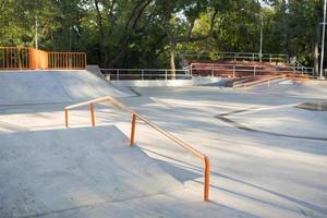 bmx rider treinando e fazendo truques na street plaza, bicyxle stunt rider em coccrete skatepark foto