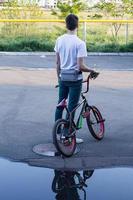 jovem macho com bicicleta bmx sozinho ao ar livre foto