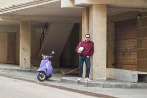 jovem homem elegante com scooter colorida foto