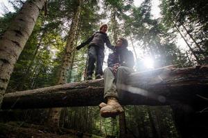 jovem casal caminhante com copos térmicos na floresta, viajantes em montanhas bebendo chá ou café foto