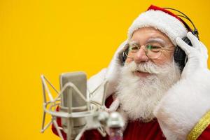 papai noel cantando ou falando em um microfone de estúdio. feliz Natal. locutor de rádio. locutor. promoção. conceito de música de natal. foto