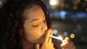uma triste garota latina fuma tarde da noite. foto