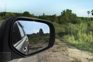 visão abstrata da natureza ao lado de carros por trás através da asa de espelhos de um carro cinza. foto