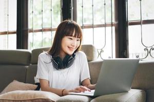 feliz sorriso estudante universitário estuda on-line ficar em casa via internet. foto