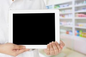 farmacêutico mostrando computador tablet na farmácia foto