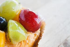 fechar a pastelaria dinamarquesa com frutas na mesa de madeira foto