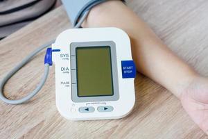 mulher usando monitor de pressão arterial digital foto
