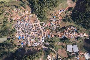vista aérea da aldeia rural local no vale distante na zona rural entre a floresta tropical foto