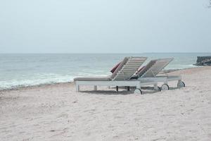 duas espreguiçadeiras na praia tropical - tempo de férias foto