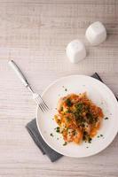 peixe com cenoura, verduras e garfo vista superior foto