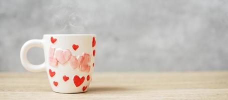 caneca de café no fundo da mesa de madeira pela manhã, espaço de cópia em branco para texto. dia internacional do café, feliz dia dos namorados e conceito de rotina diária foto