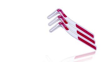 três escova interdental com tampa isolada no fundo branco com espaço de cópia de texto. conceito de atendimento odontológico. equipamento para se livrar de alimentos presos nos dentes foto